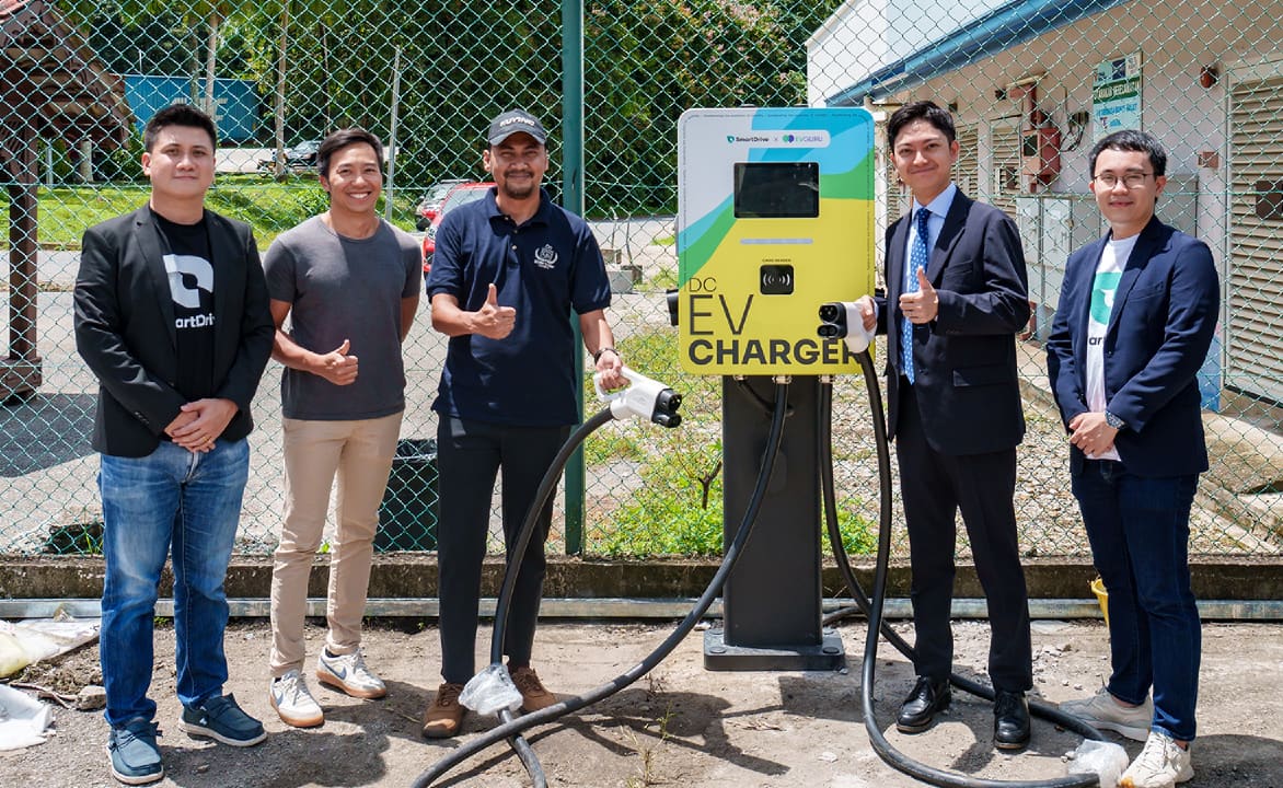 Kitagawa (second from right) poses beside newly installed SmartDrive charging station in Malaysia